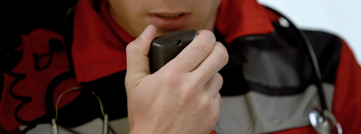 Male doctor responds by radio in ambulance, urgent call to car accident, closeup