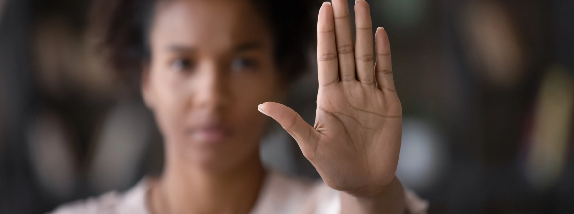 Close up of African American woman showing stop gesture with hand blurred background, young female protesting against domestic violence and abuse, bullying, saying no to gender discrimination