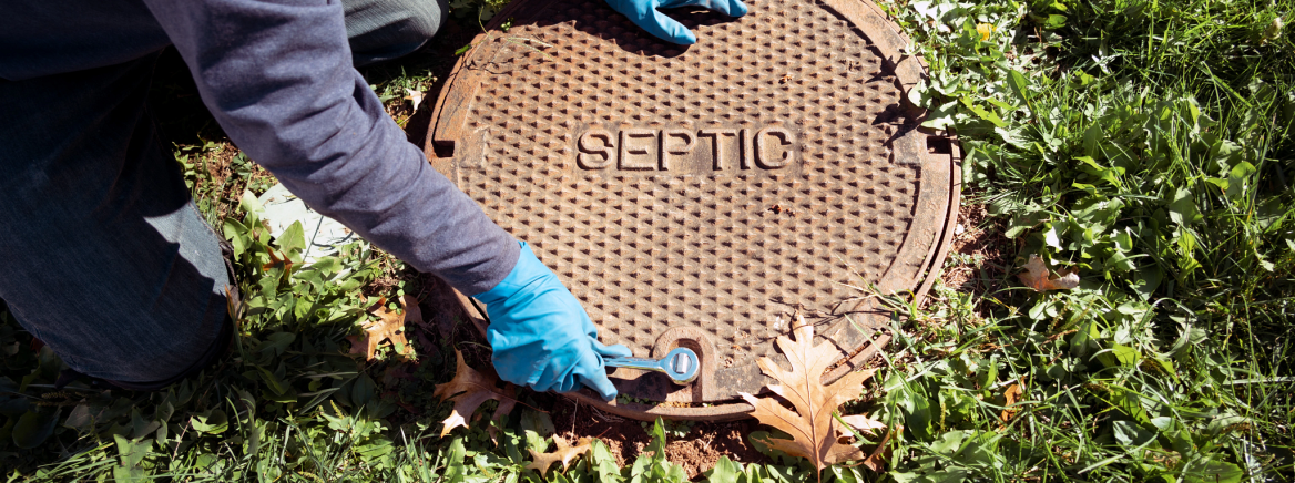 worker removing a spetic cover