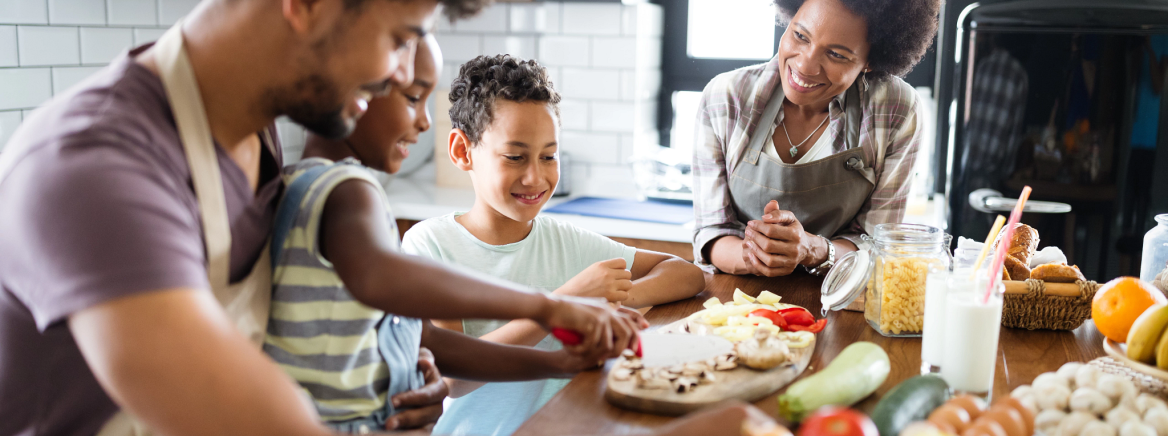 Healthy food at home. Happy black family in the kitchen having fun and cooking together