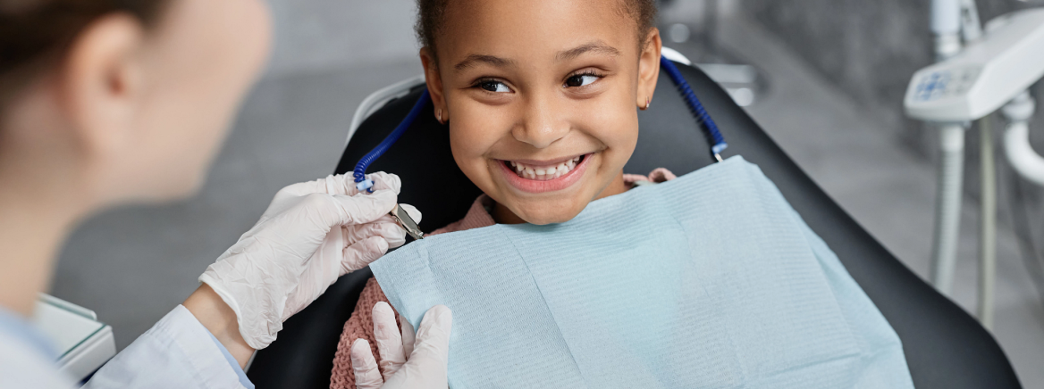 Child at dentist appointment A female child in a dental child while a female dentist conducts a dentist appointment.