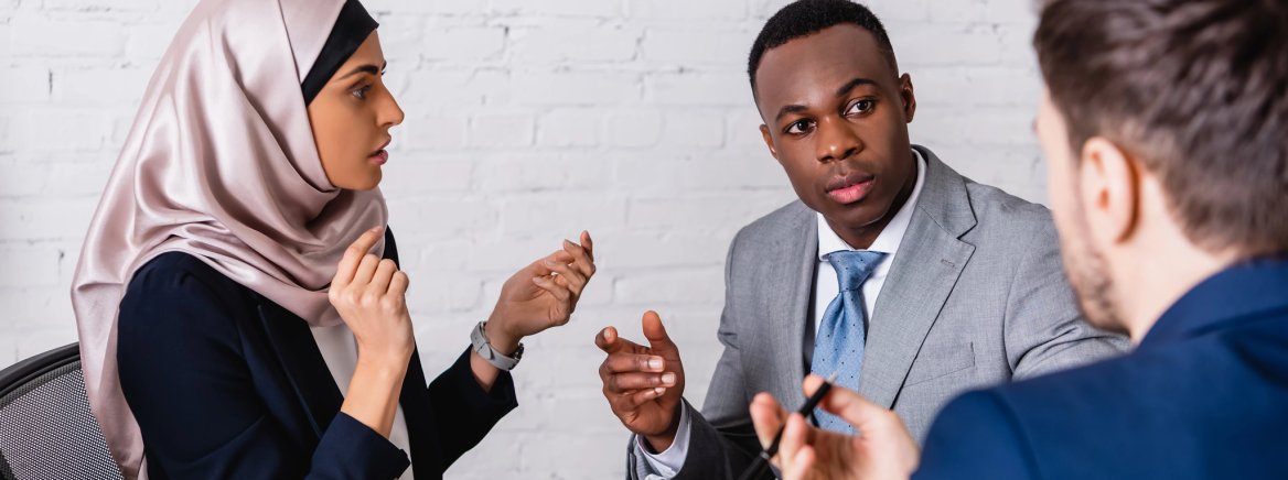 Interpreter multicultural businesspeople gesturing while discussing contract near interpreter, blurred foreground