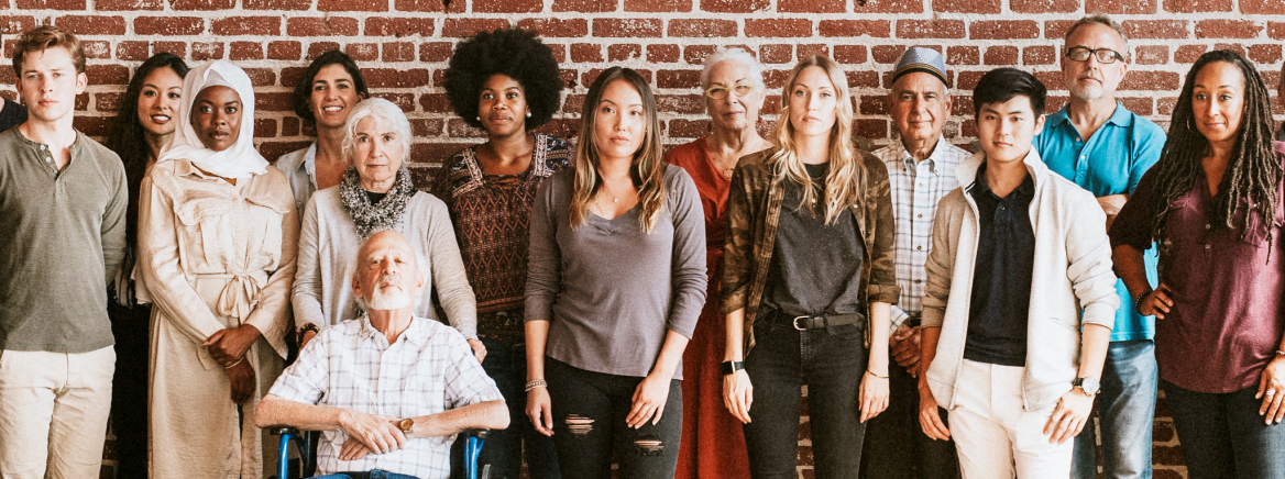 Group of diverse people standing in front of a brick wall