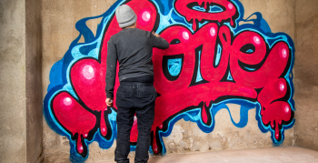 graffiti artist spraying the word love on a wall