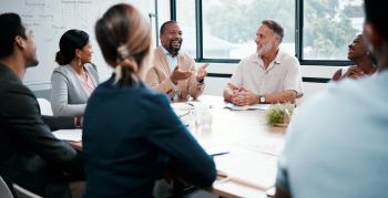 Shot of a group of businesspeople listening to a colleagues ideas during a meeting.