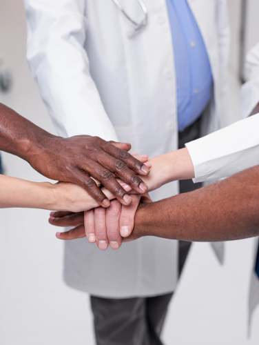Group of diverse medical professionals putting their hands out