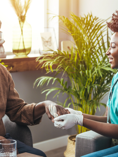 Closeup of a support hands. Closeup shot of a young woman holding a senior man's hands in comfort. Female carer holding hands of senior man