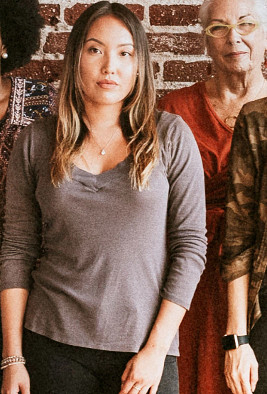 Group of diverse people standing in front of a brick wall